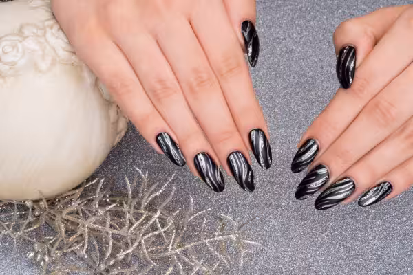 A woman's hands feature a black nail design