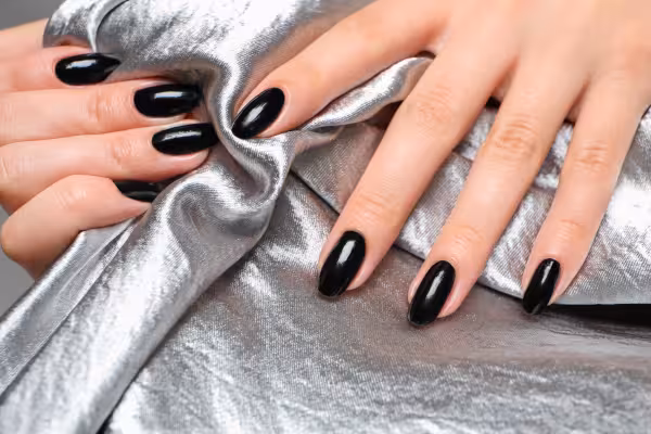 Hands with beautiful fingernails are holding a fabric
